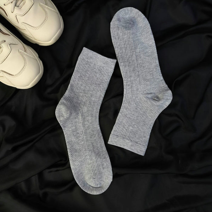 A pair of white sneakers and a pair of gray socks