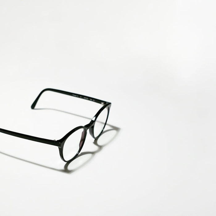 black framed eyeglasses on white surface