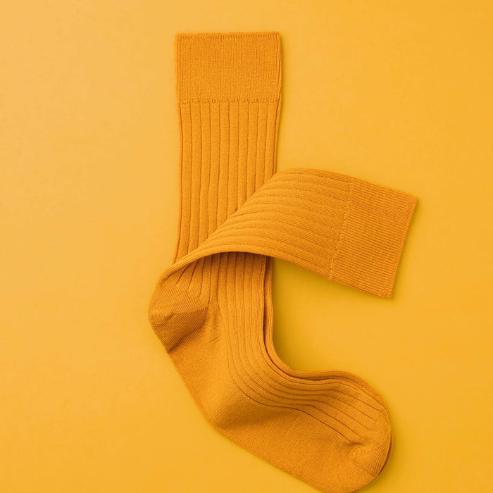 a pair of socks laying on top of a yellow surface