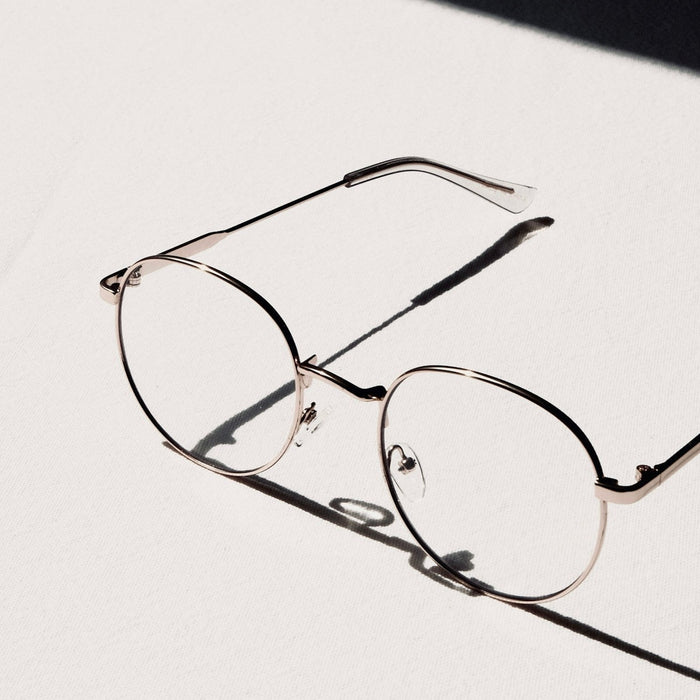 silver framed eyeglasses on white table